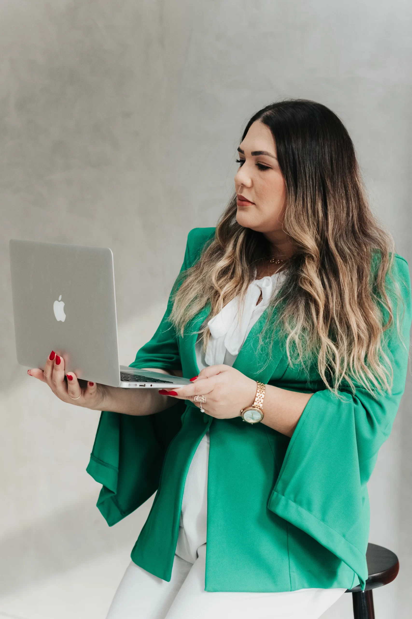 Advogada Kharen Horsts em pé segurando notebook, postura profissional e próxima do cliente, representando atendimento consultivo para empresas.